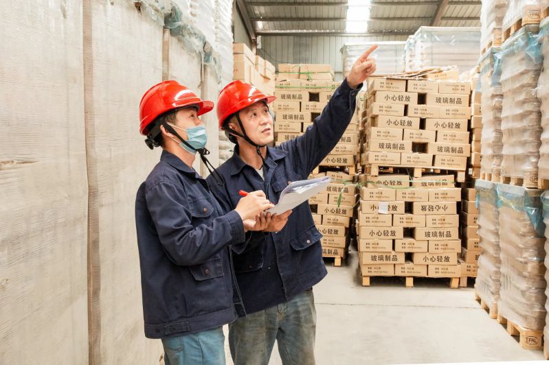 Two Employees Discuss Glass Bottle Warehouse